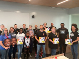 A group of people, some holding books, standing together for a picture.