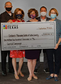 A group of Credit Union of Texas employees pose for a photo holding an extra large check.