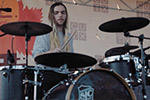 A drummer on stage playing a drum kit