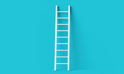 A white ladder stood up and leaning against a blue backdrop