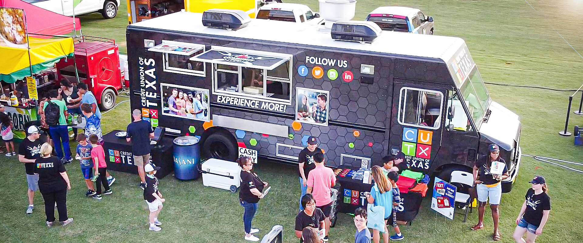 CUTX Food truck with people eating and standing around it