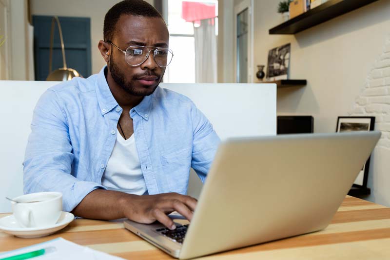 A man working on a laptop in his home