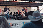 A band performing live music on stage at the Gilmer, TX town square