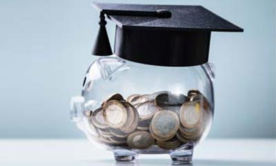 A glass piggy bank wearing a graduation cap