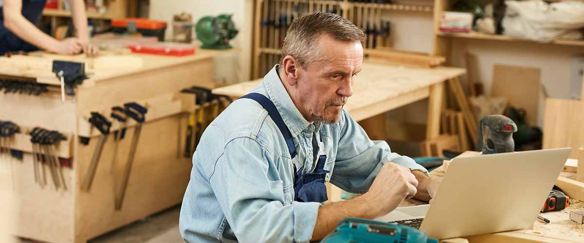 A carpenter working on a laptop